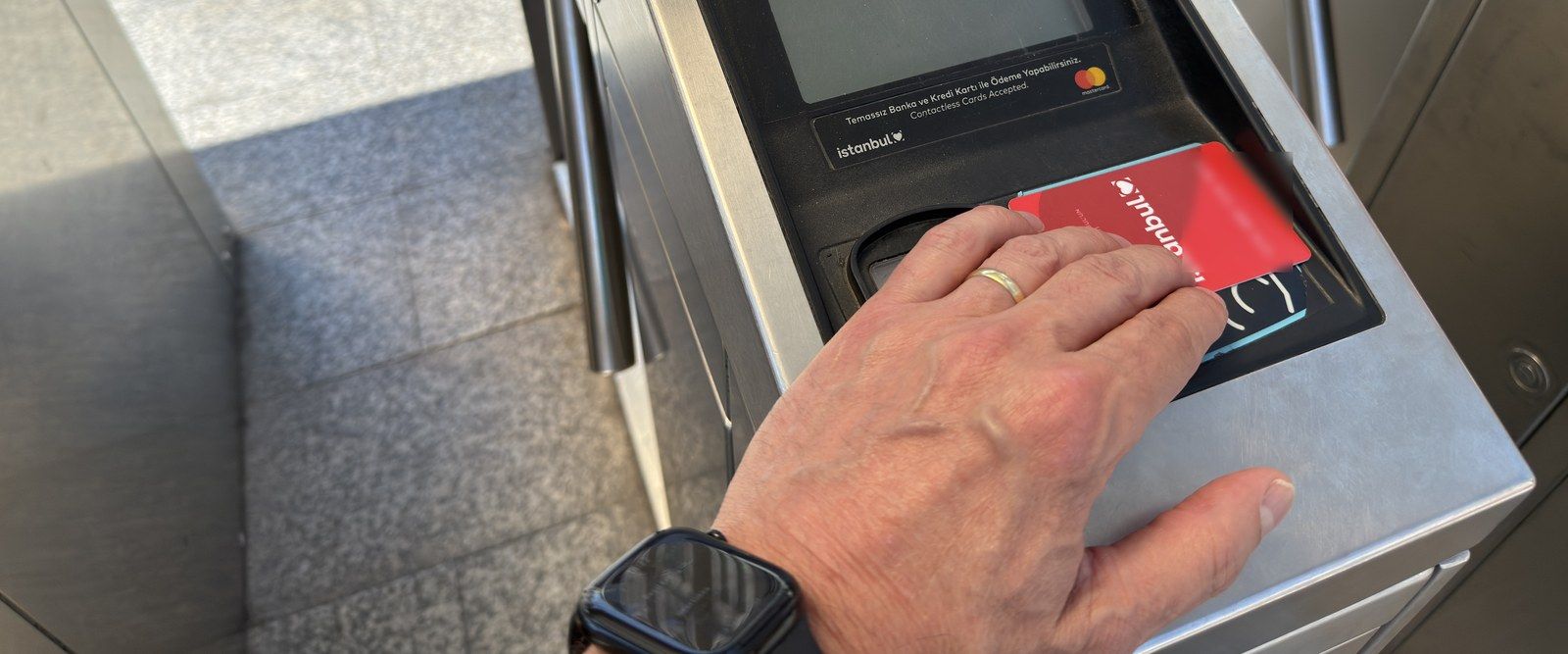 Tapping a red anonymous Istanbulkart on a turnstile card reader in Istanbul