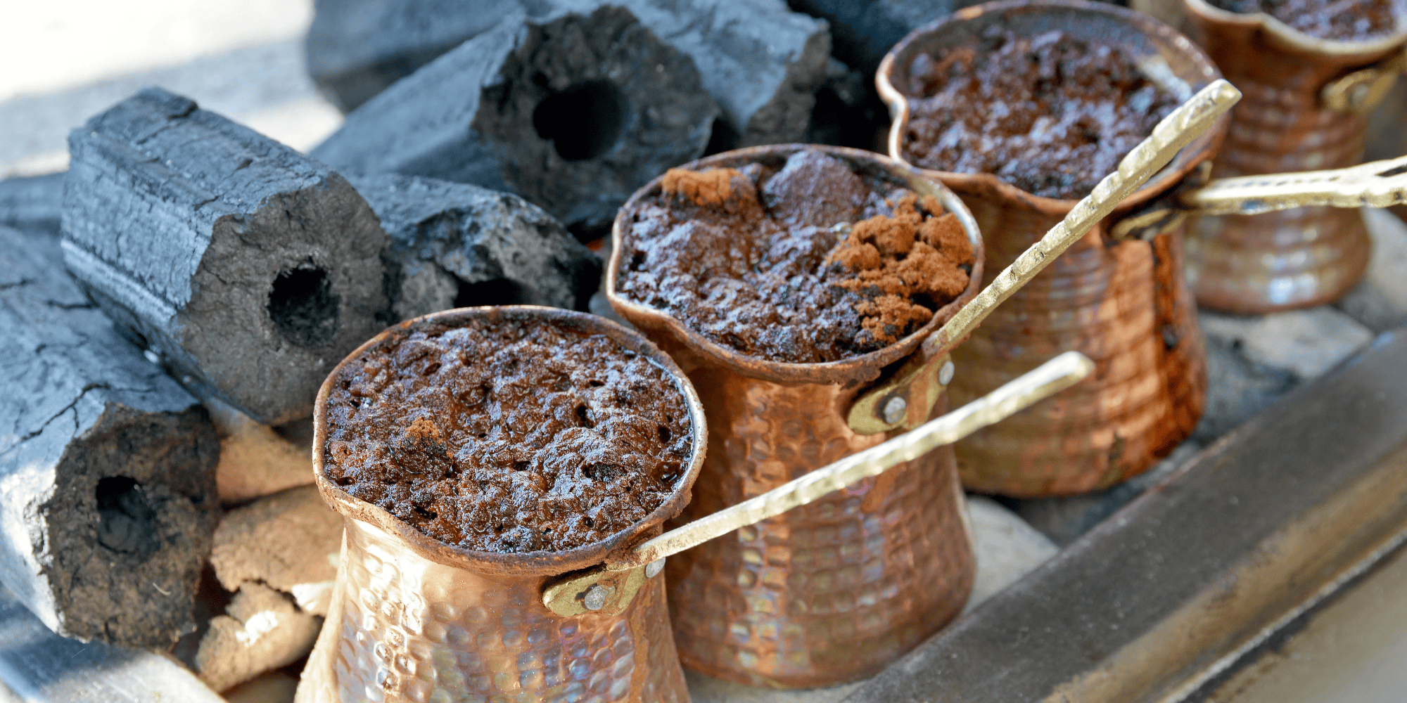 Turkish coffee cooking in copper pots in open coal fire.